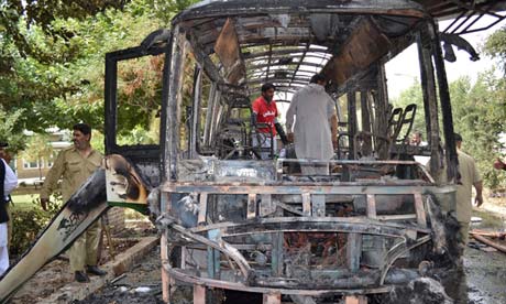 Pakistani volunteers survey the wreckage of a bus in Quetta, Pakistan