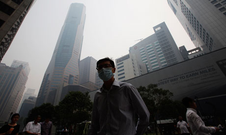 A Singapore office worker walks to work through smoke haze