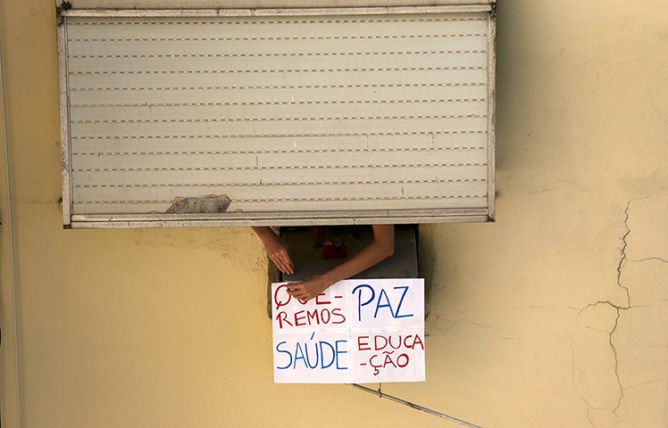 Brazil protests continue: A person hangs a sign reading, 