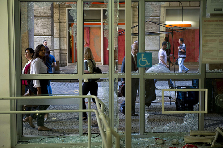 Brazil protests continue: People on their way to work pass by a ba