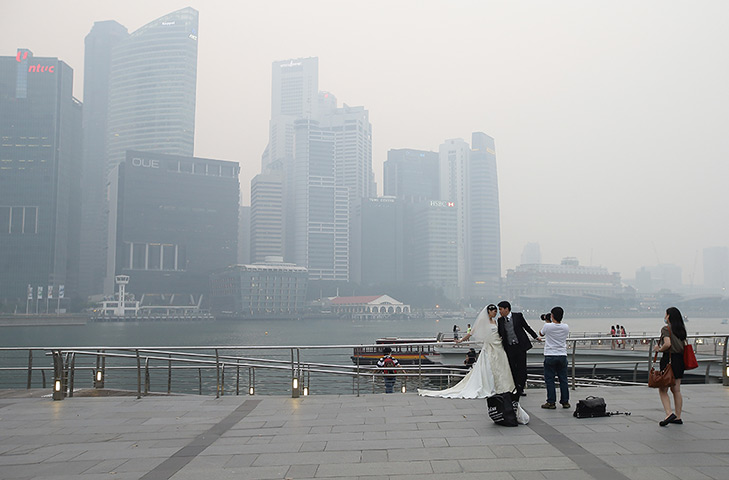 Singapore smog: A couple takes a pre-wedding photographs as the city skyline is filled with