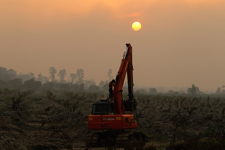 Singapore smog: A worker washes himself on an excavator at a palm oil plantation near Dumai