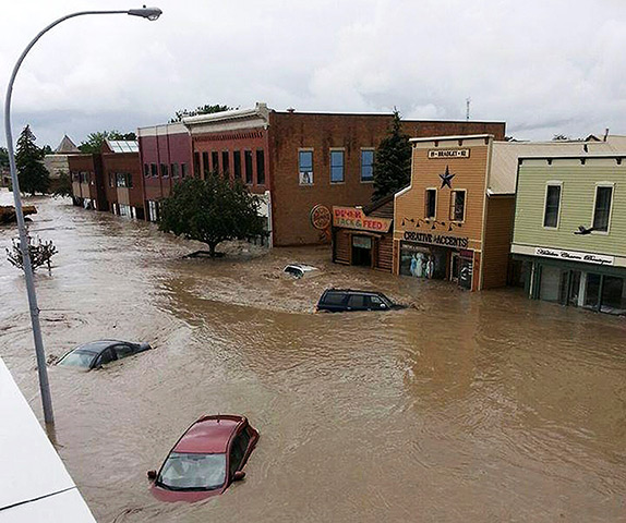 Canada floods: Cars float in water covering a downtown street in High River, Alberta
