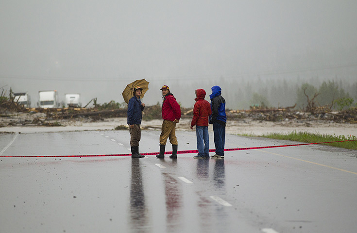 Canada floods: Bystanders look over debris deposited by Cougar Creek as it flowed up and o