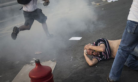 A man lies on the ground after police fired tear gas during a protest in Belo Horizonte