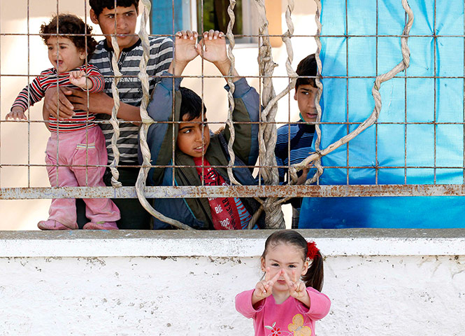 Syrian refugees: A girl flashes victory signs at Yayladagi refugee camp