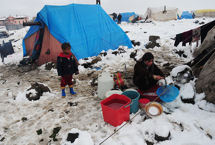 Syrian refugees: A child watches a woman washing at the refugee camp near Diyarbakir, Turkey