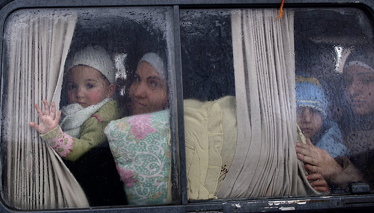 Syrian refugees: Families who have fled their home in Idlib look out of a vehicle's window 