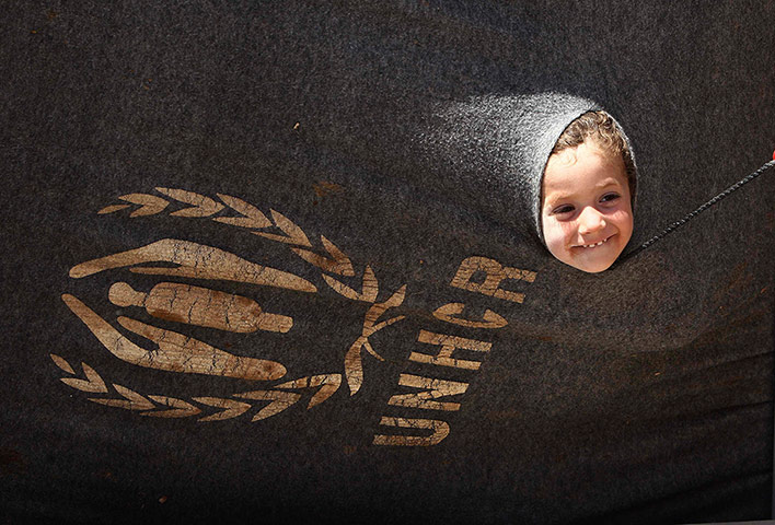 Syrian refugees: A girl looks out of her parents' tent at the Al Za'atri camp