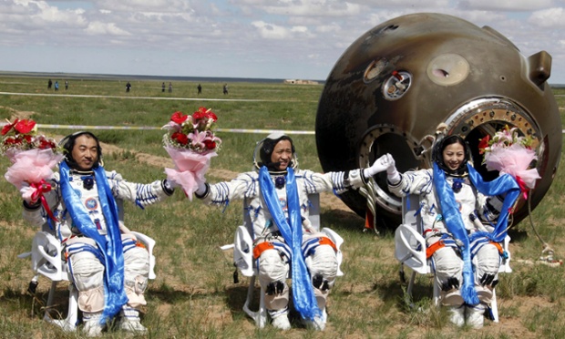 Chinese astronauts celebrate after getting out of the re-entry capsule of the Shenzhou 10 spacecraft following its successful landing in north China's Inner Mongolia Autonomous Region. The Chinese space capsule safely landed after a 15-day trip to a prototype space station.