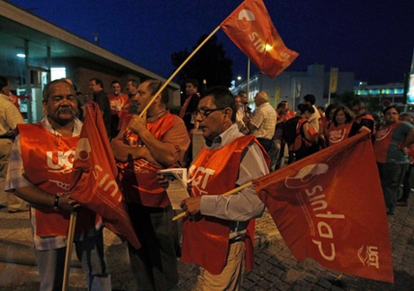 Workers hold flags at a picket line at the beginning of a general strike in Lisbon June 26, 2013.