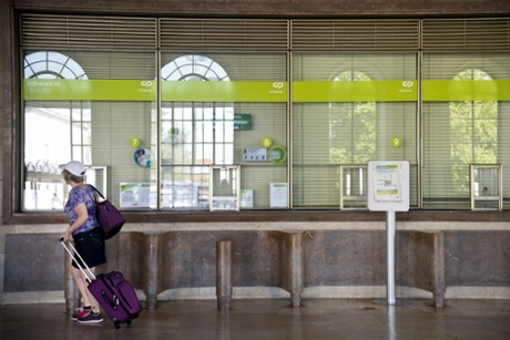 A woman passes by the closed ticketing at Santa Apolonia station during the general strike in Lisbon, on June 27, 2013.