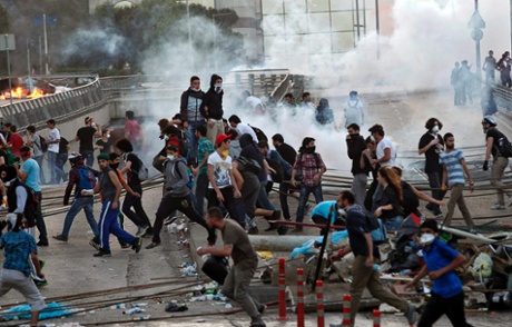 Protestors run away from Turkish riot police (out of frame) using tear gas near Taksim Square in Istanbul, Turkey, 03 June 2013.