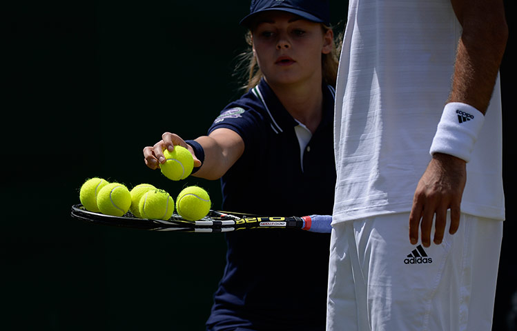 tom wimbo day 6: A ball girl places all six balls on the racket of Victor Troicki 