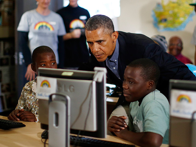 Obama Robben Island: President Barack Obama looks at a computer with youths as he tours the Desm