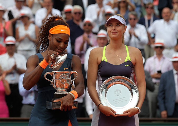 Williams v Sharapova:Serena Williams, of the U.S, left, opens the winner's cup whilst Sharapova holds the runners up plate