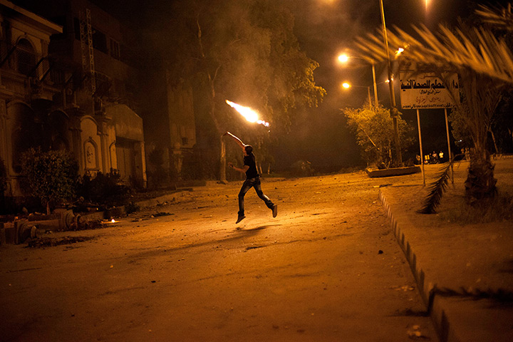Egypt protest: An Egyptian protester attacks the Muslim Brotherhood headquarters in the Mu