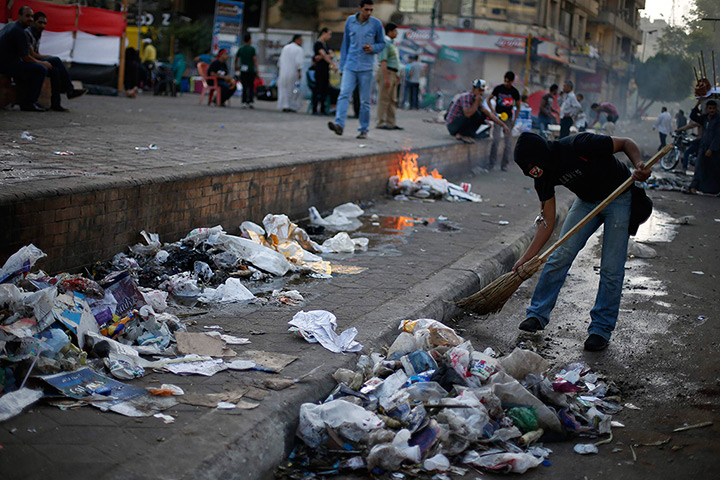 Egypt protest: A masked protester opposing Egyptian President Mohamed Mursi cleans the street