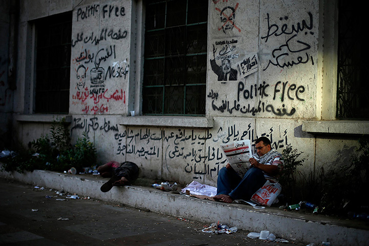 Egypt protest: A protester reads a newspaper during a sit-in protest at Tahrir Square