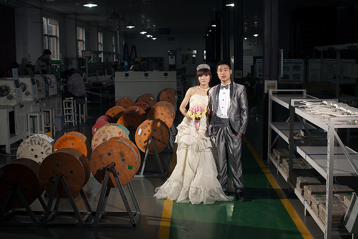 Love on the assembly line: Cheng Xu, a worker in a furniture factory poses with his wife Yuanyuan Tang