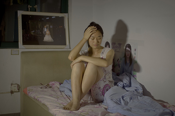 Love on the assembly line: Zhimin Lin poses for a photo in Shanghai. Her husband Guanfu Chen has start