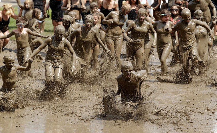 Annual mud day: Children run into the mud pit