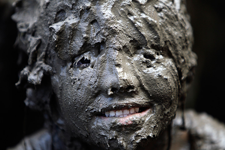 Annual mud day: Lilli Alcala, 7, of Redford, smiles while covered in mud 