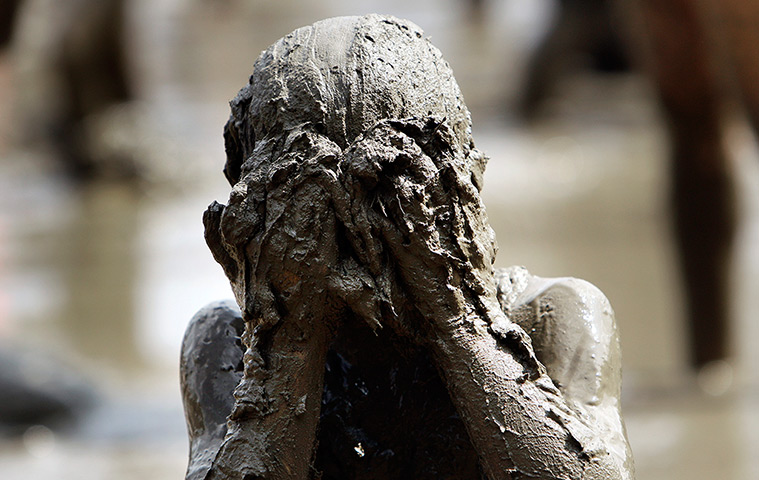 Annual mud day: Zach Miller, 10, of Livonia, wipes his face with mud