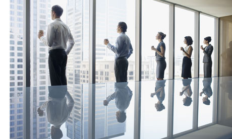 Business people drinking coffee and looking out window in conference room 