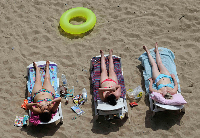 weather: Sunbathers enjoy the sunshine on South Beach, in Tenby, West Wales