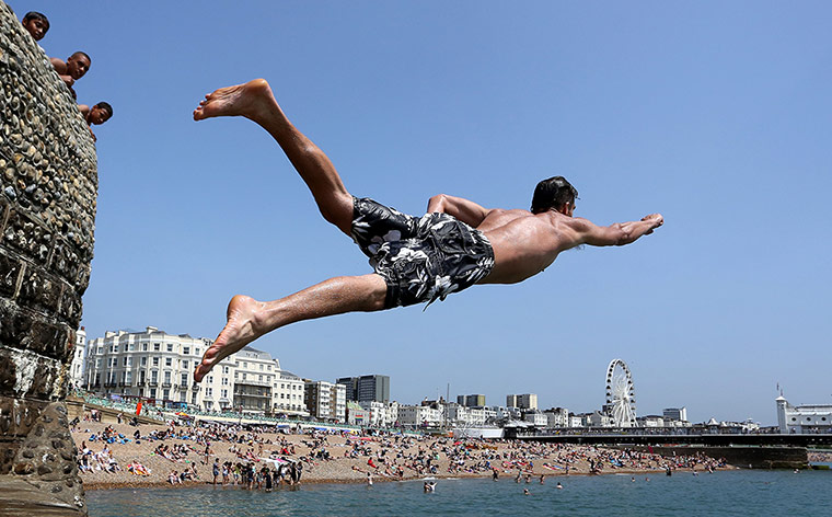 weather: Andrew Smith leaps off the sea wall in Brighton, East Sussex
