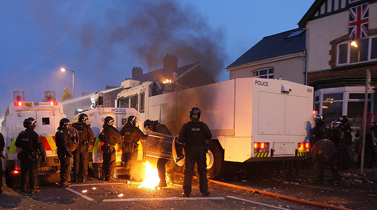 Belfast unrest: Police personnel try to extinguish flames as protesters hurl petrol bombs o