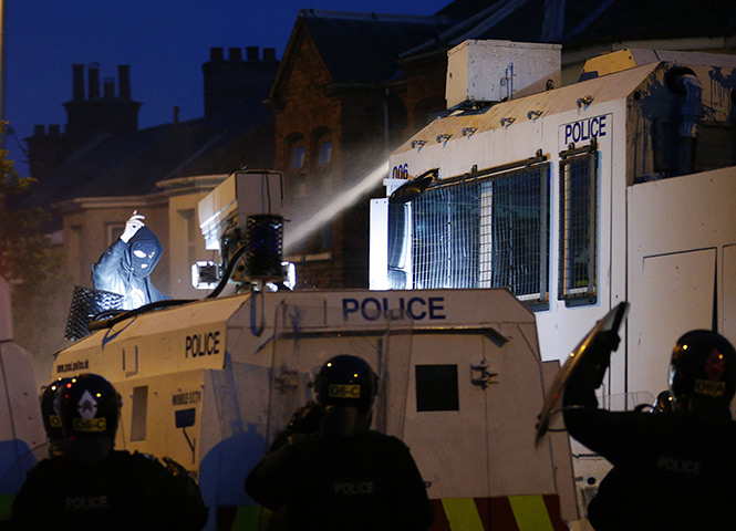 Belfast unrest: A loyalist rioter confronts riot police in the Woodvale area. Hundreds of p