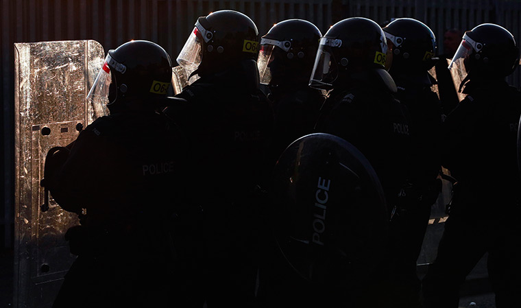 Belfast unrest: Police officers stand behind their riot shields during a clash with loyalis