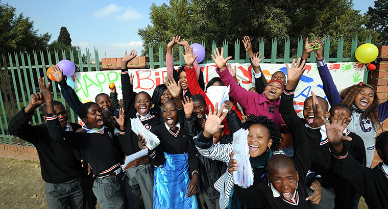 Mandela's birthday: Teachers and students from The Lukho Lwen School hold cards in Soweto