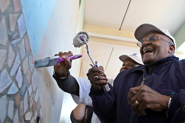 Mandela's birthday: Desmond Tutu paint a wall at the Marconi Beam Public Primary School