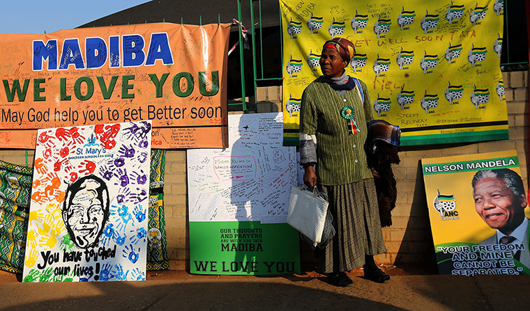 Mandela's birthday: A woman stands in front of posters and get well messages outside the Medi-C
