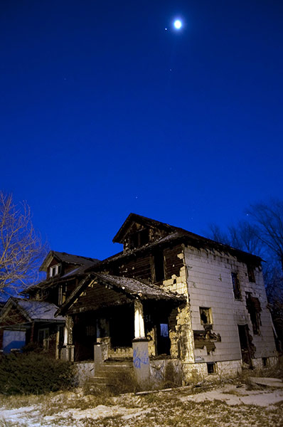 motor city blues: The moon and the planet Jupiter hover over a burned out house on Wagner Str