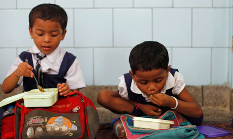 Indian schoolgirls eat their free midday meal in New Delhi