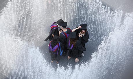 A group of graduates cool off by entering a fountain at the Southbank in London