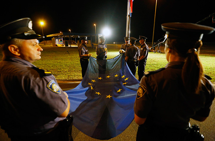 Croatia border patrols: Croatian policemen prepare to raise the EU flag for the first time at the B