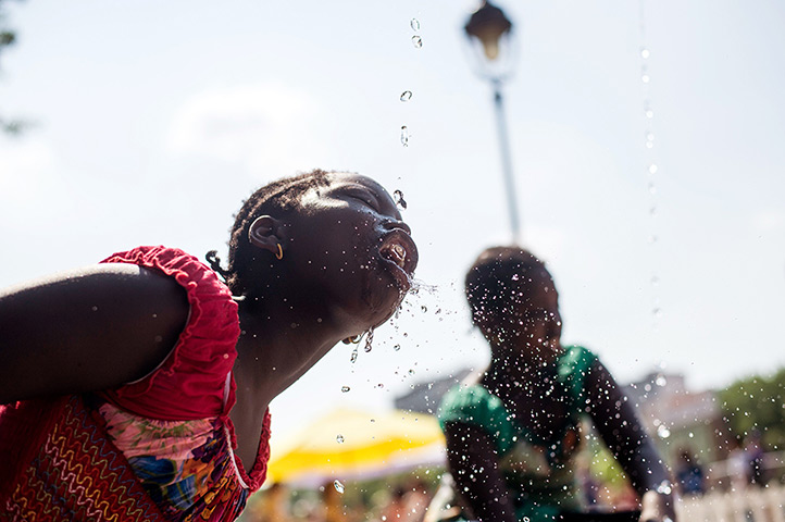 Weekend in pictures: Paris, France: A girl drinks water on a hot summer day 