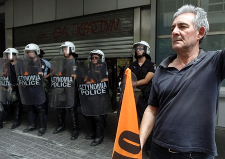 A teacher stands in front of riot police during a protest against public sector reforms and layoffs outside the Finance Ministry in Athens July 22, 2013.
