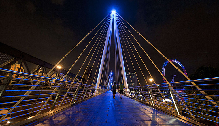 Royal blue: The Golden Jubilee Bridges are illuminated in London