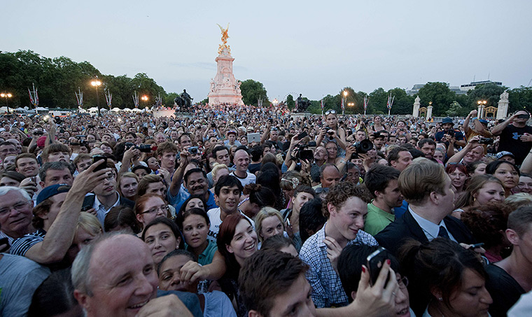 Royal blue: Crowds gather to see an easel in the forecourt of Buckingham Palace 
