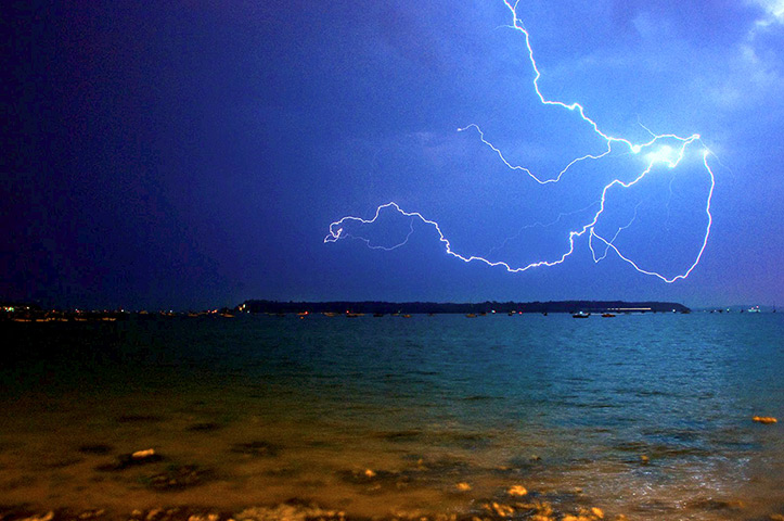 Stormy weather: Lightning flashes across the sky above Poole Harbour in the early hours of 