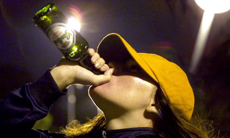 Teenager in baseball cap drinking on the streets.