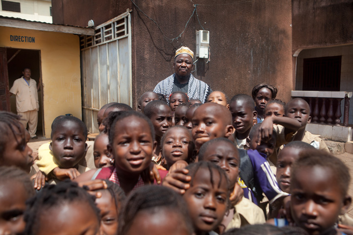 Mohamed Alakama Doumbouya with a large group of children, in Guinea