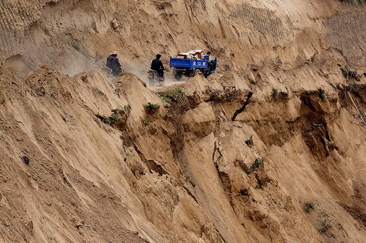 China earthquake: Motorcycles travel on a road at the site of a landslide 