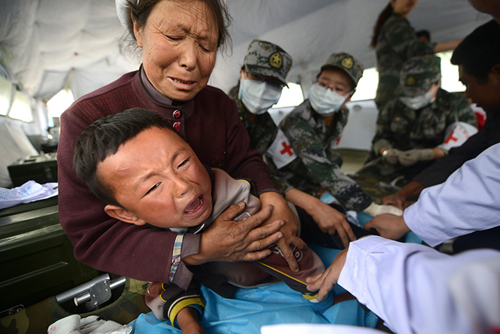 China earthquake: A boy cries as he receives treatment in a temporary shelter set up for quak